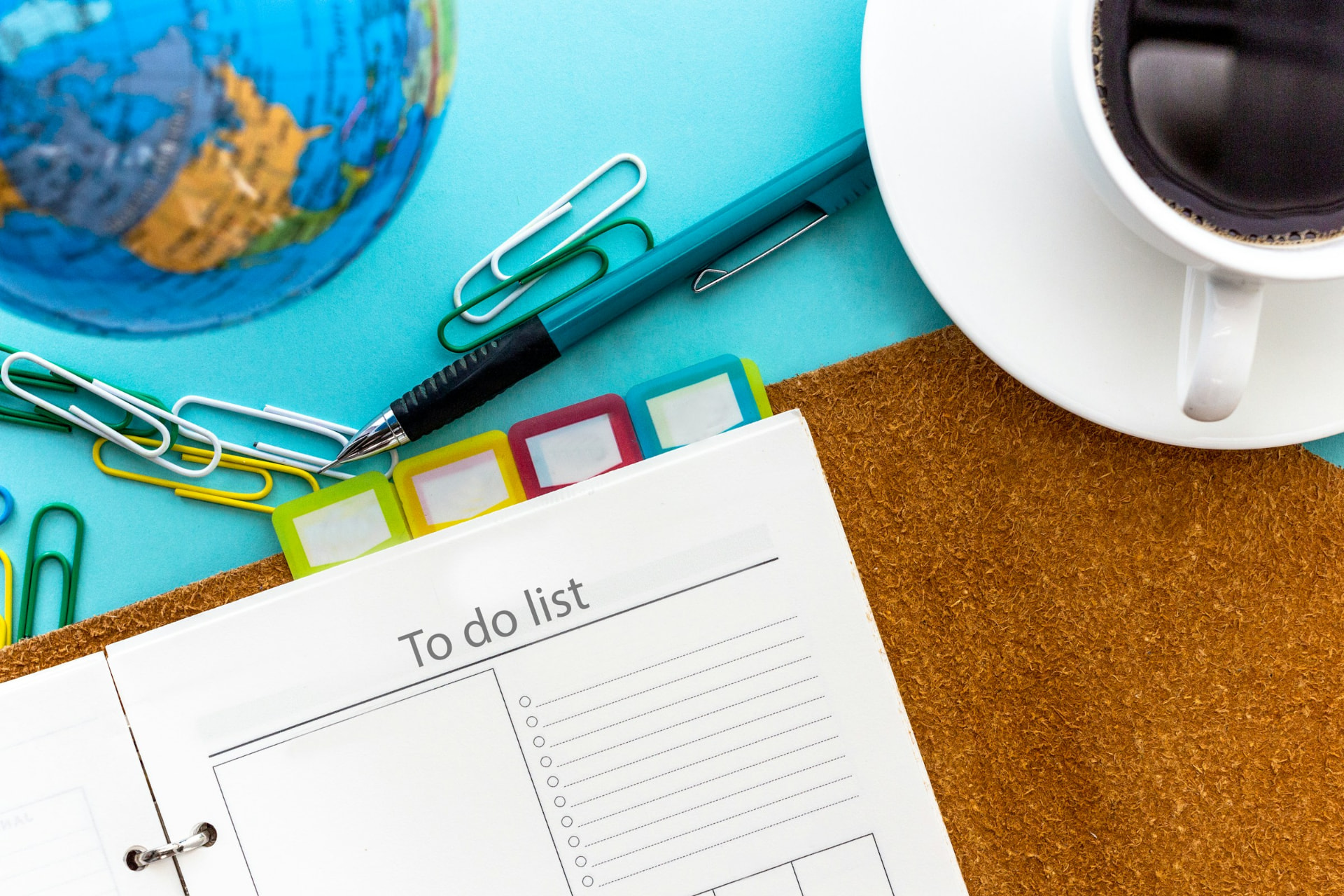 A paper to do list planner beside a cup of coffee